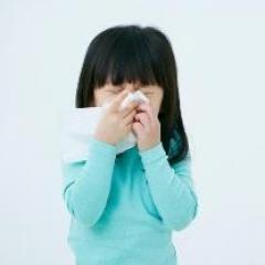 Small girl with tissue to face