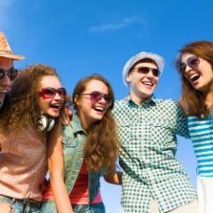 Six smiling teens standing in a line