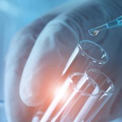 Gloved hand pipetting into test tube